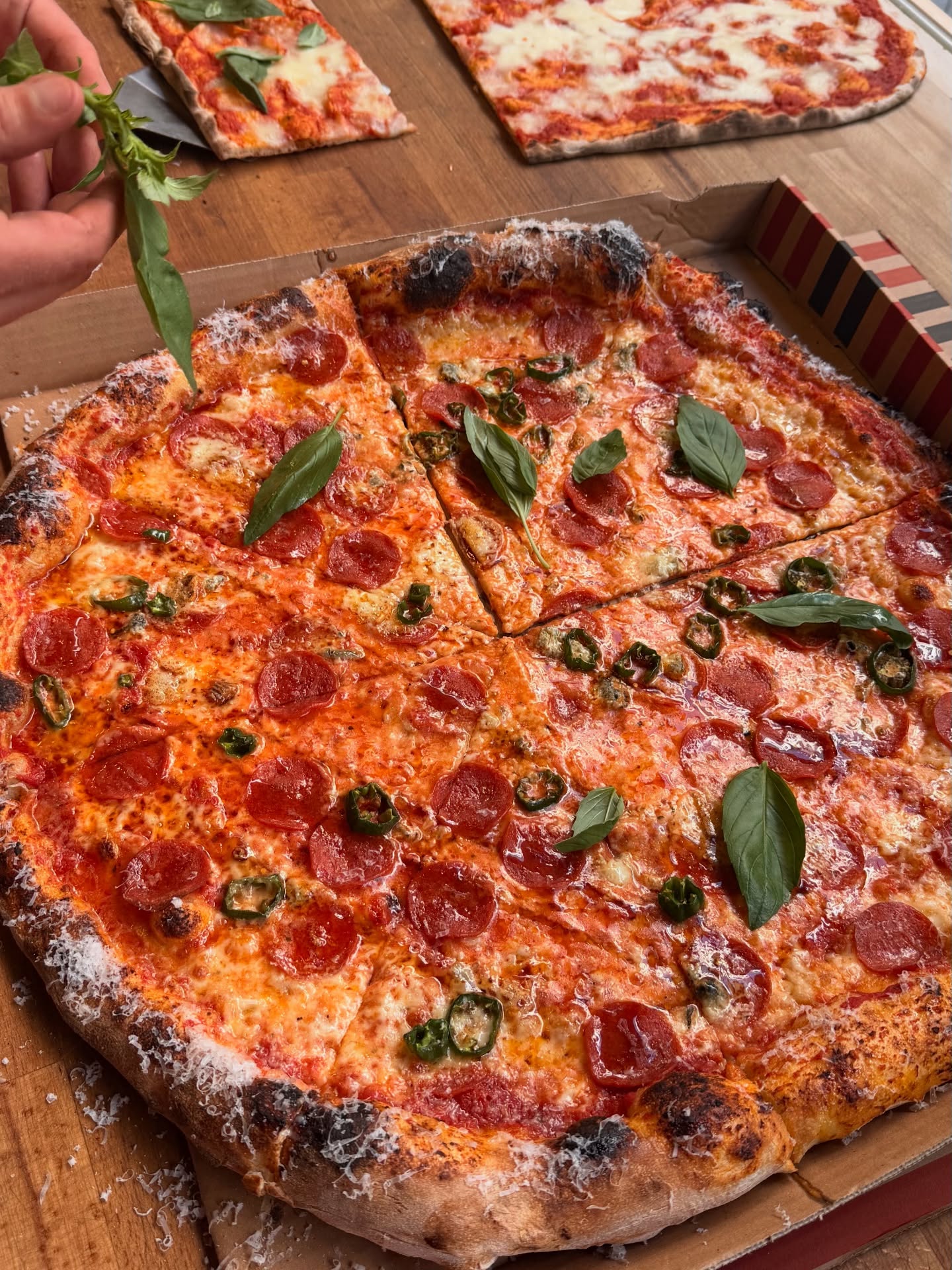 Runde Pepperoni-Pizza mit frischem Basilikum